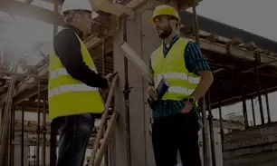 Deux ouvriers qui discutent sur un chantier.