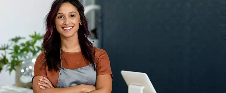 Femme qui sourit en tenue de travail coiffure