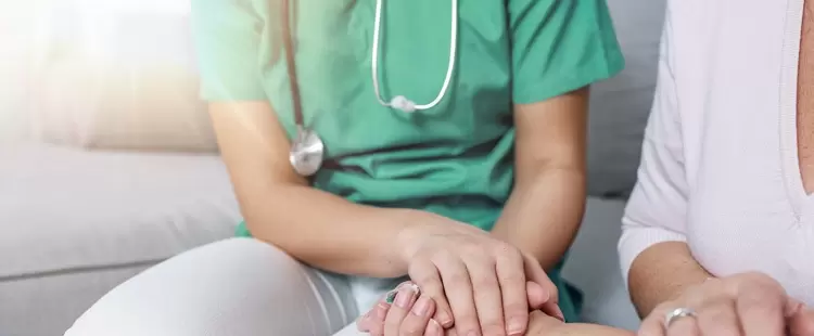 Infirmière tenant la main d'un patient.