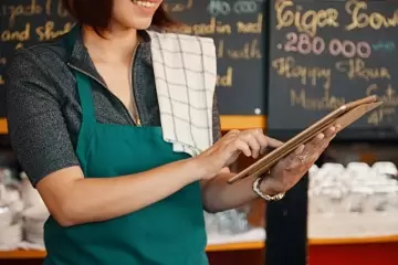 Serveuse qui encaisse des clients.