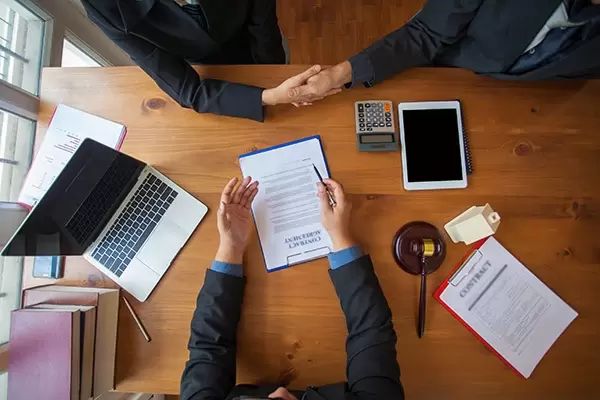 Bureau vu du dessus avec ordinateur et papiers.